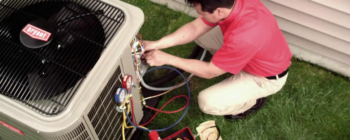 HVAC technician servicing an outdoor air conditioner unit in Concord, MA
