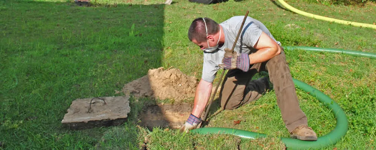 Septic pumping technician servicing a residential septic tank in Concord, MA