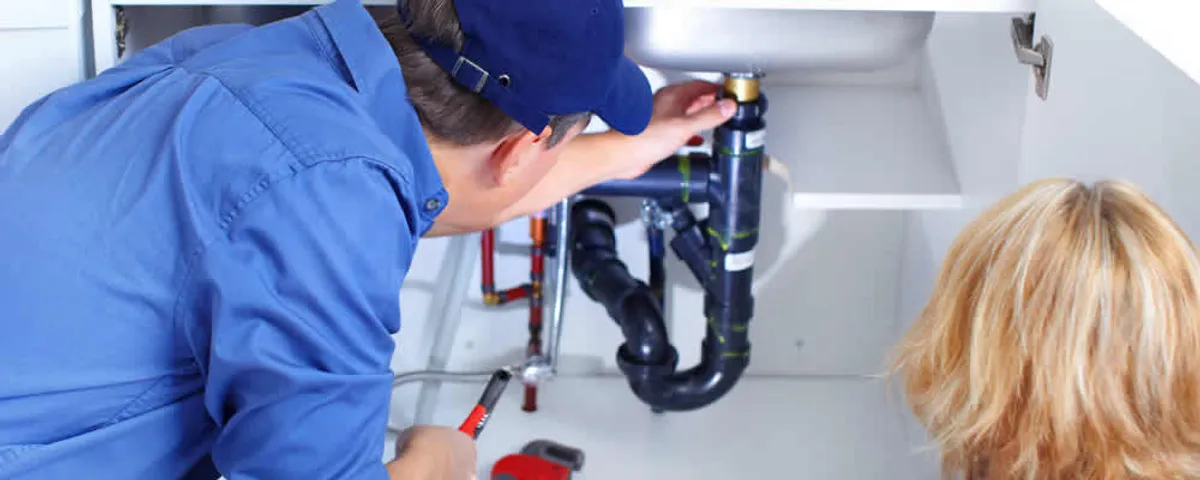 Plumber repairing under-sink drain pipes and fittings in Concord, MA